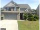 Charming two-story home with a gray brick facade, well-maintained lawn, and an attached two-car garage at 2282 Joplin St, Jonesboro, GA 30236