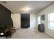 Bright living room with neutral carpet, dark accent wall, and ample natural light from the large windows at 2282 Joplin St, Jonesboro, GA 30236
