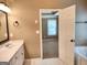 Bathroom featuring a white sink, tan walls, and an open doorway to a bedroom at 308 Bell Isle, Mcdonough, GA 30252