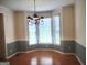 The dining room features hardwood floors, wainscotting, an elegant chandelier and a bay window at 308 Bell Isle, Mcdonough, GA 30252