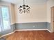 The dining room features hardwood floors, wainscotting, and an elegant chandelier at 308 Bell Isle, Mcdonough, GA 30252