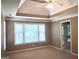 Spacious main bedroom with tray ceilings and bright window, carpeted floors at 308 Bell Isle, Mcdonough, GA 30252