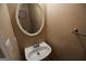 Cozy half bath with a decorative mirror and a pedestal sink at 235 Woodstream Way, Fayetteville, GA 30214