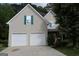 Charming home with a two-car garage, neutral stucco, and unique teal window shutters at 235 Woodstream Way, Fayetteville, GA 30214