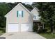 Traditional home with a two-car garage, surrounded by mature trees and a lush green lawn at 235 Woodstream Way, Fayetteville, GA 30214
