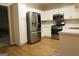 Modern kitchen featuring stainless steel appliances, white cabinets and countertops, and wood-look flooring at 235 Woodstream Way, Fayetteville, GA 30214