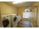 Functional laundry room with a washer, dryer, shelving, and ample counter space at 235 Woodstream Way, Fayetteville, GA 30214