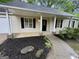 Inviting entrance featuring a covered porch, black mulch, and a well-manicured landscaped path at 6026 Woodcreek Dr, Woodstock, GA 30188