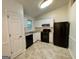Well-lit kitchen featuring white cabinets, black appliances, and tile flooring at 6026 Woodcreek Dr, Woodstock, GA 30188