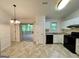 Functional kitchen featuring white cabinets, black appliances, and tile flooring, providing a modern look at 6026 Woodcreek Dr, Woodstock, GA 30188