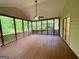 Relaxing screened porch with wood flooring and views of the surrounding lush greenery at 6026 Woodcreek Dr, Woodstock, GA 30188