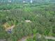 Aerial view showcasing a home nestled within a dense forest near a lake at 428 Turner Rd, Mcdonough, GA 30252