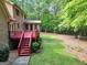 Backyard view showcasing a red deck with stairs and lush green lawn at 428 Turner Rd, Mcdonough, GA 30252