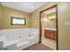 Bathroom featuring large garden tub with tile surround, separate shower, and wood vanity at 428 Turner Rd, Mcdonough, GA 30252
