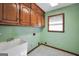 Practical laundry room with cabinet storage, utility sink, and a window for natural light at 428 Turner Rd, Mcdonough, GA 30252
