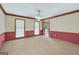 Spacious living room with carpet, wallpaper with wood trim, and natural light from the three windows at 428 Turner Rd, Mcdonough, GA 30252