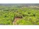 Aerial view of a pond surrounded by a dense, green forest and a home at 679 Bo Bo Banks Rd, Grantville, GA 30220