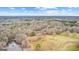 Aerial view featuring a large wooded lot, pond and a clear, blue sky above at 679 Bo Bo Banks Rd, Grantville, GA 30220
