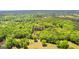 Scenic aerial view of a verdant wooded property featuring a tranquil pond, ideal for a peaceful retreat at 679 Bo Bo Banks Rd, Grantville, GA 30220