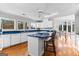Bright kitchen featuring an island with chairs, white cabinets and stainless steel appliances at 679 Bo Bo Banks Rd, Grantville, GA 30220
