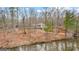 View of the lake and the back of the home with an elevated back porch at 679 Bo Bo Banks Rd, Grantville, GA 30220