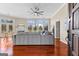 Open concept living room with gray sofa, fireplace, and large windows looking out to a wooded area at 679 Bo Bo Banks Rd, Grantville, GA 30220