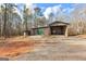 Outbuilding with a green door surrounded by a forest and open gravel area at 679 Bo Bo Banks Rd, Grantville, GA 30220