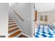 Stairway leads to kitchen with blue checkered flooring, cabinets, stove, and walk out doors at 679 Bo Bo Banks Rd, Grantville, GA 30220