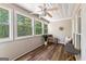 A cozy, sunlit sunroom with multiple windows, wood floors, and seating at 679 Bo Bo Banks Rd, Grantville, GA 30220