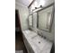 Bathroom featuring dual sinks, decorative mirrors, modern lighting, and tiled floors at 223 Rivers Rd, Fayetteville, GA 30214