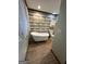 Bathroom featuring a clawfoot tub, stylish wall paneling, window with curtain, and tile flooring at 223 Rivers Rd, Fayetteville, GA 30214