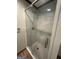 Modern glass-enclosed shower with white tile and updated fixtures, plus tile flooring at 223 Rivers Rd, Fayetteville, GA 30214