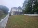 Spacious backyard featuring a screened porch, bordered by a white picket fence and lush greenery at 320 Weatherly Drive, Fayetteville, GA 30214