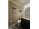 Cozy powder room featuring stylish vanity, elegant round mirror, and modern fixtures at 320 Weatherly Drive, Fayetteville, GA 30214