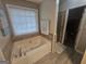 Jetted tub with tile surround, window, and shower at 320 Weatherly Drive, Fayetteville, GA 30214