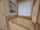 Jetted tub with tile surround and window at 320 Weatherly Drive, Fayetteville, GA 30214