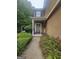 Close-up of front door entrance with lush landscaping, a 'Welcome' sign, and an ADT security sign at 320 Weatherly Drive, Fayetteville, GA 30214