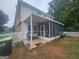 Relaxing screened porch with seating, offering a serene view of the expansive backyard and picket fence at 320 Weatherly Drive, Fayetteville, GA 30214