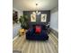 A stylish sitting area with wood flooring, accent wall and a plush navy chaise lounge sofa at 5894 Par Three Ct, Lithonia, GA 30038