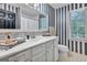 Stylish bathroom with a vanity, large mirror, and striped walls at 4250 Edgewater Nw Ct, Kennesaw, GA 30144