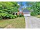 Traditional brick home featuring a manicured lawn, mature trees, and a spacious driveway at 4250 Edgewater Nw Ct, Kennesaw, GA 30144