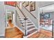 Staircase with dining room view, wooden floors, and natural light at 4250 Edgewater Nw Ct, Kennesaw, GA 30144