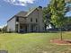 Spacious backyard with a well-maintained lawn, mature trees, and covered patio area for outdoor enjoyment at 101 Elkins Blvd, Locust Grove, GA 30248
