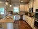 Well-lit kitchen boasts granite countertops, stainless steel appliances, island with seating, and ample cabinet space at 101 Elkins Blvd, Locust Grove, GA 30248