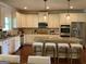 Bright eat-in kitchen features an island with bar stool seating, stainless steel appliances, and white cabinets at 101 Elkins Blvd, Locust Grove, GA 30248