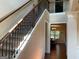 Hallway featuring carpeted stairs, dark metal railings, and open doorway at 101 Elkins Blvd, Locust Grove, GA 30248