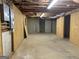 Unfinished basement with concrete floors and plywood-paneled walls, providing a blank canvas for customization at 115 Stable Creek Rd, Fayetteville, GA 30215