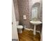 Charming powder room featuring floral wallpaper, hardwood floors, and a pedestal sink at 115 Stable Creek Rd, Fayetteville, GA 30215