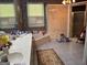 Bright bathroom featuring a soaking tub, large vanity with double sinks, and tiled floors at 115 Stable Creek Rd, Fayetteville, GA 30215