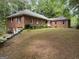 Expansive brick home with a well-manicured lawn and mature trees, offering classic charm and a serene setting at 115 Stable Creek Rd, Fayetteville, GA 30215
